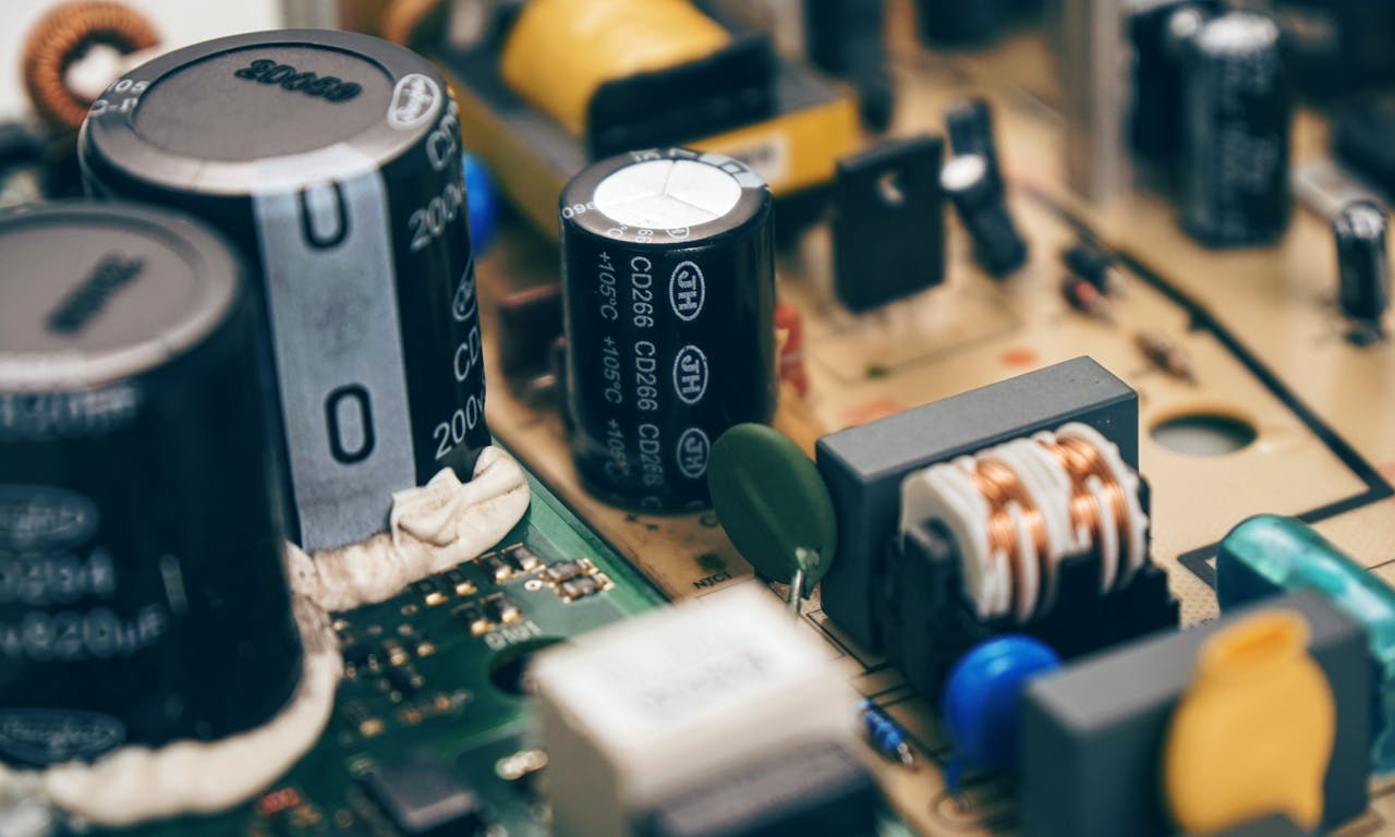 our-story-01 Detailed close-up of capacitors and components on a circuit board, showcasing electronic technology.